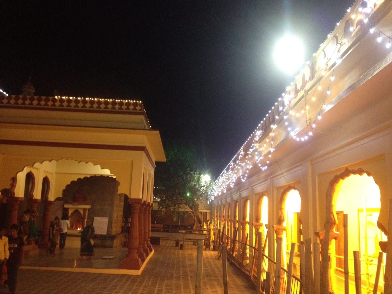 The lit arcade around the courtyard of the Morgaon Ganesha temple at night