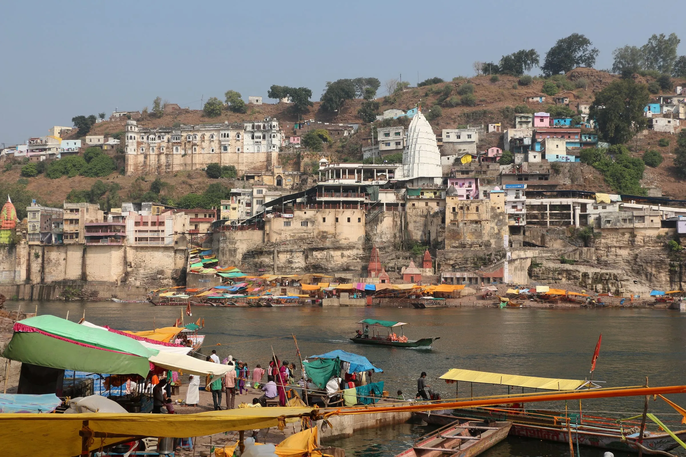 Omkareshwar temple seen from the river, with boats moored below
