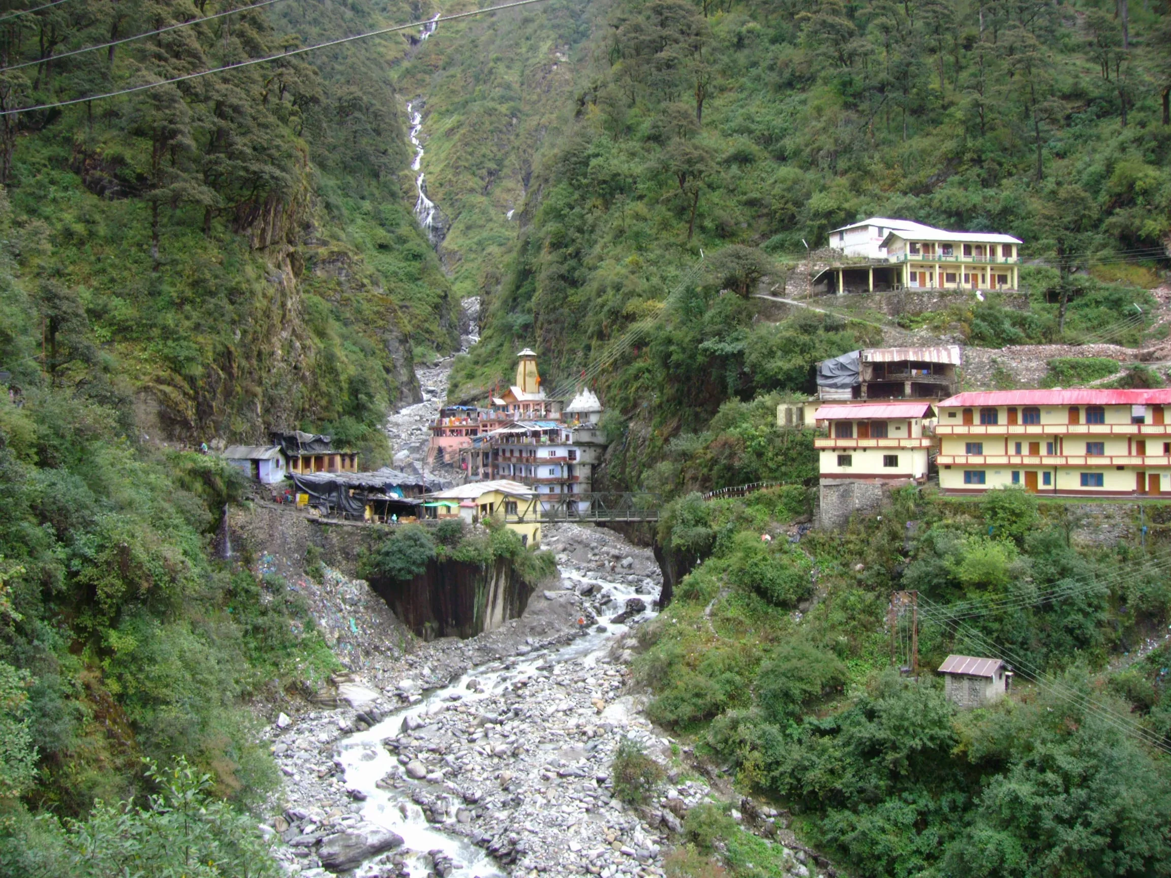 Yamunotri temple and ashram beside the river in a steep, forested gorge