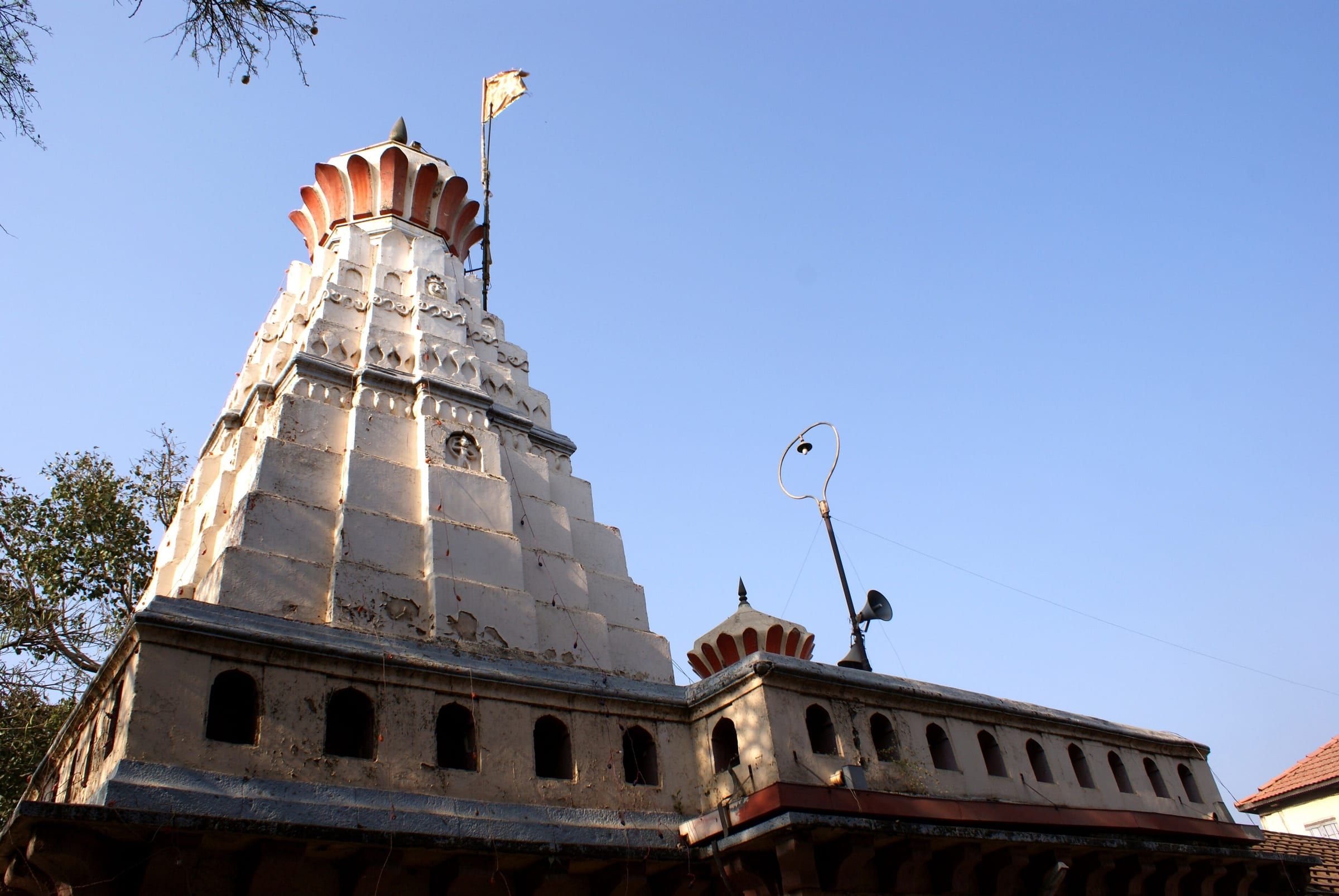 The white spire of the Chintamani temple at Theur against a blue sky