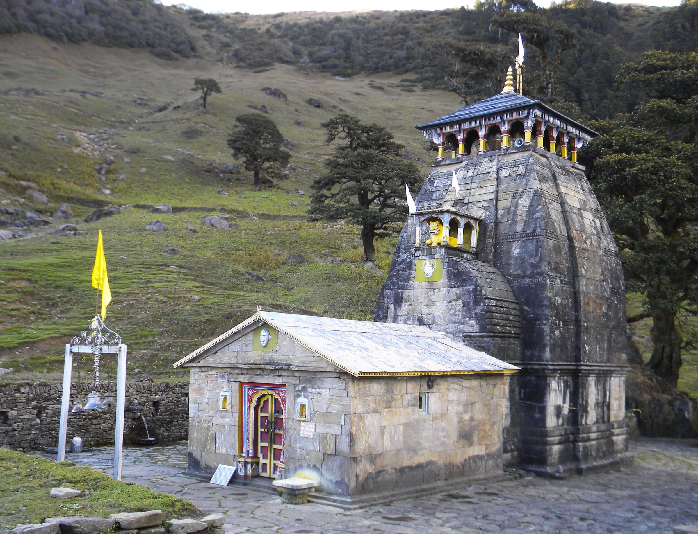 Madhyamaheshwar Temple's stone spire in a high meadow